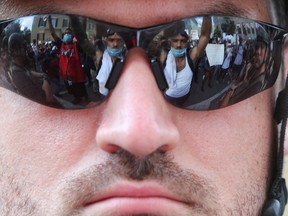 Protesters are seen reflected in the glasses of a law enforcement personnel during a rally against the death in Minneapolis police custody of George Floyd, near the White House in Washington, U.S., June 3, 2020.