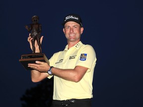 American Webb Simpson celebrates with the trophy after winning  the RBC Heritage on Sunday.
