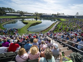 Spectators sit around the 17th hole during the first round of The Players Championship golf tournament at TPC Sawgrass - Stadium Course in Ponte Vedra Beach, Fla., on March 12, 2020. The tournament was called off after the first round, and the PGA Tour hasn't had a tournament since.