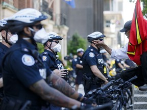 A protestor confronts a Toronto Police officer during an anti-racism march on June 6, 2020 in Toronto. Calls to defund the Toronto Police Service by 10% are reckless, short-sighted and irresponsible, writes Etobicoke North Coun. Michael Ford.