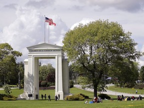 In this photo taken May 17, 2020, people walk back and forth across the border between the U.S. and Canada in Peace Arch Park in Blaine, Washington.