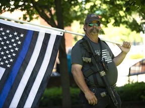 Josh Bradley holds a thin blue line flag during a Patriot Prayer and Peoples Rights Washington rally against the Washington state mask mandate outside the Clark County Sheriffs Office on June 26, 2020 in Vancouver, Washington. Washington state Governor Jay Inslee ordered a statewide mandate requiring facial coverings be worn by anyone out in public beginning today in an effort to slow the spread of coronavirus (COVID-19) which is seeing a rise of cases in the state and across the country. Bradley said he attended the rally to stand for his freedom. Our rights are being trampled on, Bradley said.