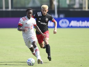 Richie Laryea  of Toronto FC carries the ball past Yamil Asad  of D.C. United during a match in the MLS Is Back Tournament at ESPN Wide World of Sports Complex on July 13, 2020 in Reunion, Florida. The final score was 2-2.