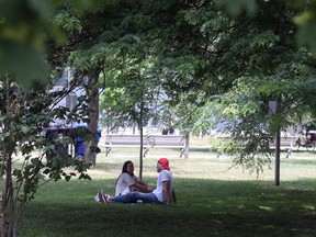 A couple enjoy the hot and humid weather at Trinity Bellwoods Park on Sunday.