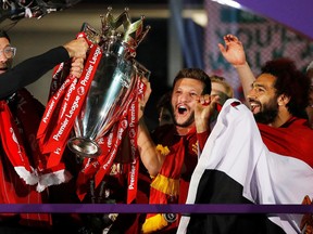 Liverpool manager Juergen Klopp, Adam Lallana and Mohamed Salah celebrate with the trophy after winning the Premier League last week.