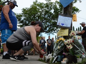 Residents of the Danforth area leave flowers and light candles for the victims at the scene of last night shooting in Toronto, Ontario on July 23, 2018.