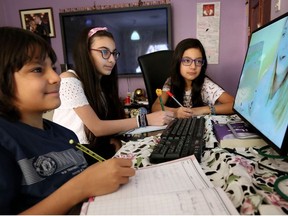 Children continue their school curriculum online via a computer screen at their home in Kuwait City on March 23, 2020.