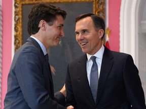 In this file photo taken on November 20, 2019, Prime Minister Justin Trudeau shakes hands with Minister of Finance Bill Morneau during a ceremony at Rideau Hall in Ottawa.