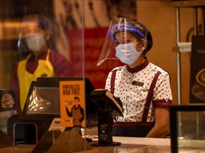 PVR Cinemas employees wearing face shields, gloves and facemasks, participate in a sanitisation work as part of preparations for a possible reopening amid concerns over the spread of the COVID-19 coronavirus, in New Delhi on July 31, 2020.