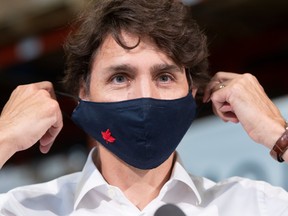 Prime Minister Justin Trudeau removes his face mask at the start of a news conference in Gatineau, Que., July 3, 2020.