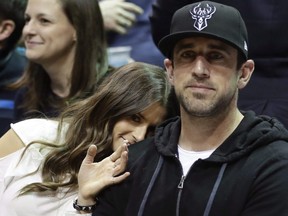 In this April 20, 2018 file photo Danica Patrick and Packers QB Aaron Rodgers watch during the first half of Game 3 of an NBA basketball first-round playoff series between the Milwaukee Bucks and the Boston Celtics in Milwaukee.