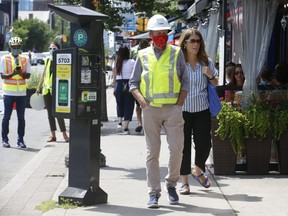 Toronto Mayor John Tory and former city councillor Mary Fragedakis — now Executive Director at GreekTown on the Danforth BIA — stroll through Greektown near newly installed bicycle lanes on Saturday July 25, 2020.