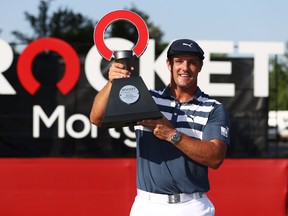 Bryson DeChambeau holds the trophy after winning the Rocket Mortgage Classic on Sunday.