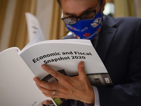 CP-Web.  A copy of the federal government's Economic and Fiscal Snapshot 2020 is thumbed through as reporters take part in a media lock-up for the in Ottawa on Wednesday, July 8, 2020. THE CANADIAN PRESS/Sean Kilpatrick ORG XMIT: SKP106