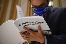 CP-Web. A copy of the federal government's Economic and Fiscal Snapshot 2020 is thumbed through as reporters take part in a media lock-up for the in Ottawa on Wednesday, July 8, 2020. THE CANADIAN PRESS/Sean Kilpatrick ORG XMIT: SKP106