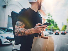 Courier delivery food service at home. Man courier using a map app on mobile phone to find the delivery address in the city