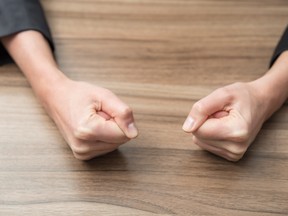 Closeup image of two businesswoman's fists on a wood table