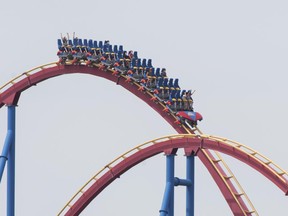 People wear face masks as they ride 'The Goliath', roller coaster at La Ronde amusement park in Montreal, Saturday, July 25, 2020.