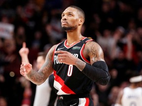 Portland Trail Blazers guard Damian Lillard (0) gestures after making a three point basket against the Golden State Warriors during the second half at Moda Center.