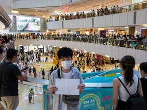 Protesters hold up blank papers during a demonstration in a mall in Hong Kong, China, Monday, July 6, 2020.