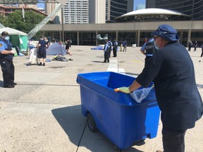 Cleanup crews on scene as tents are taken down outside Toronto City Hall on Friday, July 10, 2020.