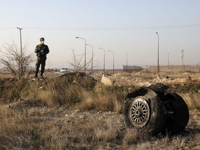 A police officer stands guard as debris is seen from an Ukrainian plane which crashed in Shahedshahr, southwest of the capital Tehran, Iran, January 8, 2020.