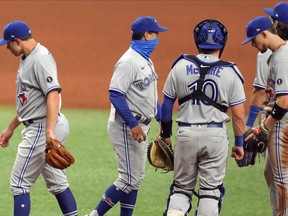 Blue Jays manager Charlie Montoyo (centre) removes pitcher Sam Gaviglio (left) from the game in the eighth inning on Saturday at Tropicana Field.