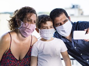 Happy family with protective masks take a selfie.