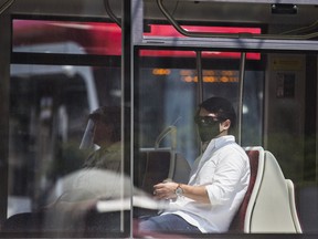 A rider on a TTC streetcar at Queen St. W. and Spadina Ave. in Toronto on Thursday, July 2, 2020.