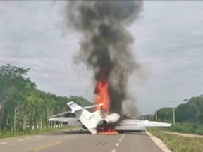 A plane suspected of carrying drugs was reportedly set alight after allegedly being intercepted by soldiers on Federal Highway 184 in Quintana Roo, Mexico, July 5, 2020 in this still image taken from video.