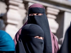 In this file photo taken May 31, 2018, women wearing niqabs leave the Danish Parliament in Copenhagen, Denmark.