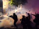 Federal officers deploy tear gas and less-lethal munitions while dispersing a crowd of about a thousand protesters in front of the Mark O. Hatfield U.S. Courthouse on Thursday, July 24, 2020 in Portland, Oregon.