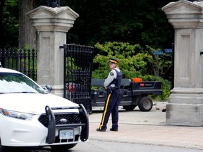 A police officer stands near a damaged gate at Rideau Hall, the property where Prime Minister Justin Trudeau lives, after an armed man rammed the gate with a pickup truck to gain access to the grounds, in Ottawa, July 2, 2020.