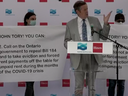 Protesters stand behind Toronto Mayor John Tory at a groundbreaking ceremony on Thursday, July 23, 2020.