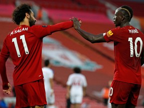 Liverpool's Senegalese striker Sadio Mane (right) celebrates scoring a goal with Liverpool's Egyptian midfielder Mohamed Salah during the English Premier League football match between Liverpool and Crystal Palace at Anfield on June 24, 2020.
