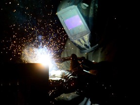 A welder fabricates a steel structure at an iron works facility in Ottawa on Monday, March 5, 2018.