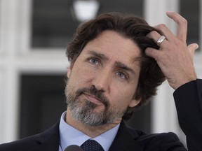 CP-Web.  Prime Minister Justin Trudeau adjusts his hair during a daily news conference outside Rideau Cottage in Ottawa, Friday May 22, 2020. THE CANADIAN PRESS/Adrian Wyld ORG XMIT: ajw101