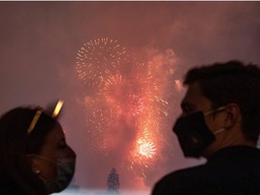 White House guests wearing protective face masks watch the Washington, D.C. fireworks display from the South Lawn of the White House as they celebrate U.S. Independence Day in Washington, U.S., July 4, 2020.