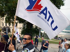A Winnipeg Transit worker carries an Amalgamated Transit Union flag during the Winnipeg Labour Council's Labour Day March in Winnipeg on Mon., Sept. 2, 2019.