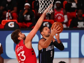 Nikola Vucevic  of the Orlando Magic goes up for a shot against Marc Gasol of the Toronto Raptors in the first half at Visa Athletic Center at ESPN Wide World Of Sports Complex on August 5, 2020 in Lake Buena Vista, Fla.