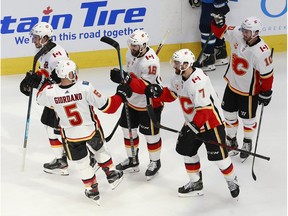 EDMONTON, ALBERTA - AUGUST 06: Sean Monahan #23 of the Calgary Flames is congratulated by his teammates after scoring an empty-net goal against the Winnipeg Jets during the third period in Game Four of the Western Conference Qualification Round prior to the 2020 NHL Stanley Cup Playoffs at Rogers Place on August 06, 2020 in Edmonton, Alberta.