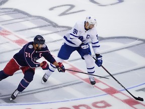 John Tavares of the Toronto Maple Leafs plays the puck against Nick Foligno of the Columbus Blue Jackets in Game Four of the Eastern Conference Qualification Round prior to the 2020 NHL Stanley Cup Playoffs at Scotiabank Arena on August 07, 2020 in Toronto, Ontario.