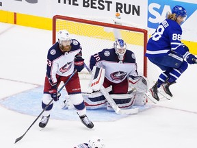 William Nylander of the Maple Leafs leaps out of the way of teammate's shot as Joonas Korpisalo and David Savard of the Columbus Blue Jackets defend in Game 5.