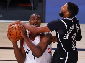 Serge Ibaka, left, of the Toronto Raptors draws a foul from Garrett Temple of the Brooklyn Nets during the fourth quarter in Game One of the Eastern Conference First Round during the 2020 NBA Playoffs at AdventHealth Arena at ESPN Wide World Of Sports Complex on August 17, 2020 in Lake Buena Vista, Fla.