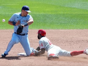 Joe Panik of the Toronto Blue Jays attempts to scoop a ball thrown by catcher Reese McGuire as Roman Quinn of the Philadelphia Phillies steals second base during the third inning on Thursday.