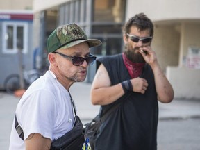 Zachary Bulkowski back) and another man are pictured outside the citys temporary shelter in the Roehampton Hotel, on Aug. 12, 2020.