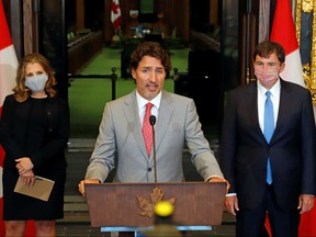 Prime Minister Justin Trudeau speaks to reporters next to Canadian Deputy Prime Minister and Finance Minister Chrystia Freeland and Minister of Intergovernmental Affairs Dominic LeBlanc on Parliament Hill in Ottawa, Aug. 18, 2020.