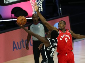 Raptors' Serge Ibaka defends at the rim against Nets' Caris LeVert during their game on Sunday.