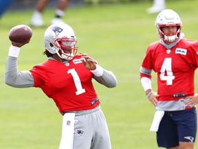 Patriots' Cam Newton makes a throw as Jarrett Stidham watches on Wednesday.