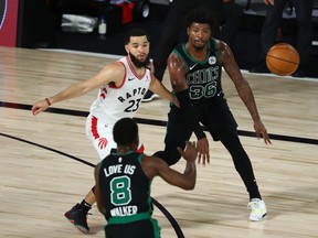 Boston Celtics guard Marcus Smart (36) passes the ball to guard Kemba Walker (8) as Toronto Raptors guard Fred VanVleet defends during the second quarter of Game 1 of their playoff series on Sunday.